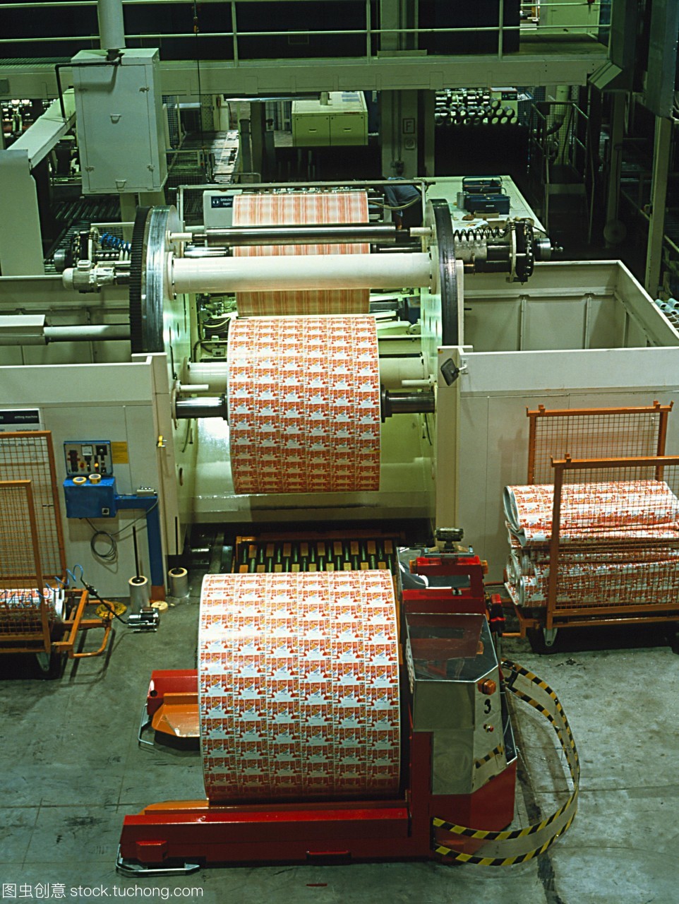 机器人车。红色机器人车辆运输一卷纸印花工厂。完成卷被从生产线上部中心为存储仓库将用于制造食品包装纸板。机器人是一个自动引导车辆形成工厂的电脑一体机制造过程的一部分。机器人的使用允许灵活的核电站周围流动的材料。